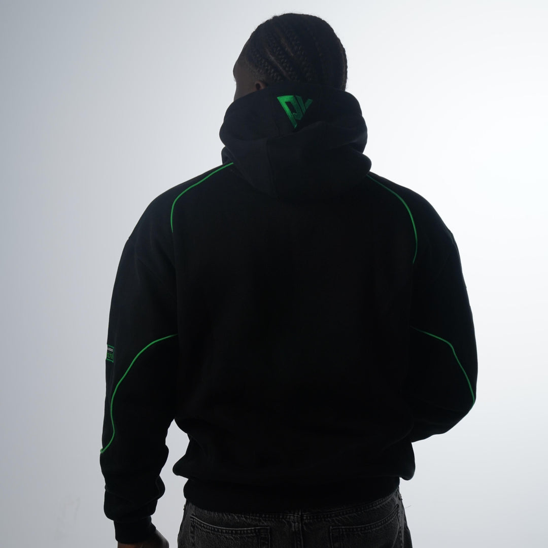 Person wearing a black hoodie with green accents on a white background