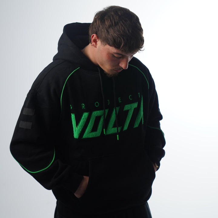 Person wearing a black hoodie with green text on a white background
